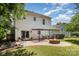 Home with brick patio with fire pit and dining area set in a grassy yard at 9107 Royal Highlands Ct, Charlotte, NC 28277