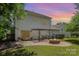 Home's backyard boasts a patio, fire pit, and a manicured lawn, creating an ideal space for relaxation at 9107 Royal Highlands Ct, Charlotte, NC 28277