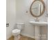 Neat bathroom featuring a pedestal sink, tiled flooring, toilet, and a framed mirror at 9107 Royal Highlands Ct, Charlotte, NC 28277