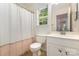 A well-lit bathroom featuring a white toilet and sink, with a window above the toilet at 9107 Royal Highlands Ct, Charlotte, NC 28277