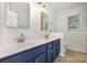Bathroom with double sinks, white countertops, blue cabinets, and modern fixtures at 9107 Royal Highlands Ct, Charlotte, NC 28277
