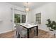 Well-lit dining area featuring a sleek table setting and easy access to the backyard through sliding glass doors at 9107 Royal Highlands Ct, Charlotte, NC 28277
