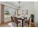Bright dining room with modern table and chairs, stylish chandelier, and large windows, perfect for Gathering meals at 9107 Royal Highlands Ct, Charlotte, NC 28277
