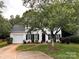 Traditional two-story home with black shutters, a lush front lawn and mature shade tree creating curb appeal at 9107 Royal Highlands Ct, Charlotte, NC 28277