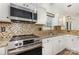 Bright kitchen showcasing modern stainless steel appliances, ample counter space, and decorative backsplash at 9107 Royal Highlands Ct, Charlotte, NC 28277