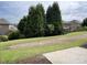 Backyard with a lush green lawn, mature trees, and a wrought iron fence at 9593 Camberley Nw Ave, Concord, NC 28027