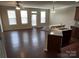 Open-concept living room with hardwood floors, ceiling fan, and breakfast bar overlooking kitchen at 9593 Camberley Nw Ave, Concord, NC 28027