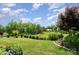 Lush backyard with manicured lawn, mature trees, and a view of the surrounding landscape at 10016 St Kitts Landing Ln, Charlotte, NC 28278
