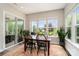 Sunlit dining area features a wooden table, black chairs, and views of the beautifully landscaped backyard at 10016 St Kitts Landing Ln, Charlotte, NC 28278