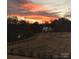 An exterior view of a home at sunset, accented by a lush landscape at 10016 St Kitts Landing Ln, Charlotte, NC 28278