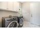Well-equipped laundry room featuring a modern washer and dryer set, plus storage cabinets at 10016 St Kitts Landing Ln, Charlotte, NC 28278