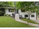 Charming white brick home with black accents and a welcoming front yard with mature tree at 1021 Nancy Dr, Charlotte, NC 28211