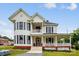 Charming two-story house featuring a welcoming porch, complemented by red accents and dark shutters at 107 Hinton St, Chester, SC 29706