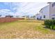 Large backyard with lawn and a wood fence, featuring other homes beyond the property at 1077 River Haven Sw Ave, Concord, NC 28025