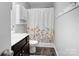 Cozy bathroom featuring a vanity, toilet, and shower/tub combo with a floral shower curtain at 1077 River Haven Sw Ave, Concord, NC 28025
