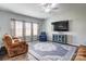 Cozy living room with a ceiling fan, large windows, and comfortable seating at 1077 River Haven Sw Ave, Concord, NC 28025