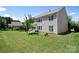 Spacious backyard with lush green grass, mature trees, and a patio area, perfect for outdoor activities at 10792 Elsfield Nw Ave, Concord, NC 28027