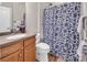Well-maintained bathroom featuring a vanity, toilet, and shower with a blue floral curtain at 10792 Elsfield Nw Ave, Concord, NC 28027