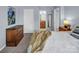Cozy bedroom with a classic wooden dresser and comfortable bedding, adjacent to a glimpse of an ensuite bathroom at 10792 Elsfield Nw Ave, Concord, NC 28027