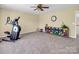 Versatile bonus room featuring neutral walls, beige carpet, ceiling fan and an area for exercise equipment and games at 10792 Elsfield Nw Ave, Concord, NC 28027