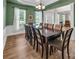 Elegant dining room with green walls, wooden table, and large windows at 10792 Elsfield Nw Ave, Concord, NC 28027