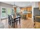 Inviting dining room features natural light, a wooden table and chairs, and a kitchen island with bar stools at 10792 Elsfield Nw Ave, Concord, NC 28027