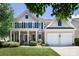 Charming two-story home with a well-manicured lawn, inviting front porch, and a two-car garage at 10792 Elsfield Nw Ave, Concord, NC 28027