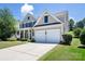 Traditional home with a two-car garage, covered front porch, and meticulous landscaping on a sunny day at 10792 Elsfield Nw Ave, Concord, NC 28027