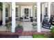 Cozy front porch with a swing, rocking chairs, and vibrant potted plants creating a welcoming outdoor space at 10792 Elsfield Nw Ave, Concord, NC 28027