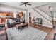 Spacious living room featuring hardwood floors, a comfortable leather couch, and a charming staircase at 10792 Elsfield Nw Ave, Concord, NC 28027