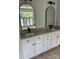 Bathroom featuring double sinks with granite countertops and sleek black faucets beneath arch mirrors at 111 Billy Joe Rd, Mooresville, NC 28117