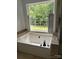 A bright bathroom showcases a luxurious soaking tub by a large window with white shutters at 111 Billy Joe Rd, Mooresville, NC 28117