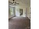 Spacious bedroom featuring a ceiling fan, tray ceiling, and an adjacent bathroom with a tub at 111 Billy Joe Rd, Mooresville, NC 28117