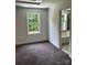 A bedroom with neutral carpeting and a window with natural light leading to an ensuite bathroom at 111 Billy Joe Rd, Mooresville, NC 28117