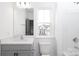 Bright bathroom features a large mirror, gray vanity, and a window view of the home's exterior at 1190 Sugar Creek Rd, Fort Mill, SC 29707