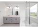 Bathroom showcasing double vanity sinks with modern fixtures and a soaking tub near a window at 1190 Sugar Creek Rd, Fort Mill, SC 29707