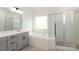 Bathroom featuring gray cabinets, quartz counters, soaker tub, and glass shower at 1190 Sugar Creek Rd, Fort Mill, SC 29707