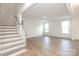 Spacious living room with hardwood floors, staircase, and natural light from large windows at 1190 Sugar Creek Rd, Fort Mill, SC 29707