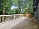 View of the wooden deck with a gated entrance perfect for outdoor entertaining and enjoying the surrounding lush greenery at 1261 Westbrook Cir, Gastonia, NC 28052