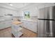 Well-lit kitchen features white cabinets, stainless steel appliances, and a portable butcher block island at 1261 Westbrook Cir, Gastonia, NC 28052