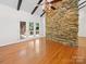 Open living space featuring wood floors, a stone fireplace, and access to an outdoor deck at 1261 Westbrook Cir, Gastonia, NC 28052