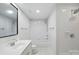 Bright bathroom with a vanity, tub with shower and modern fixtures complemented by white tile at 1315 East Blvd # 611, Charlotte, NC 28203