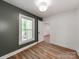 Bright bedroom with wood floors, neutral walls, white trim, and a door leading to another room at 138 Shepherd Rd, Mooresville, NC 28115