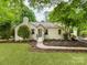 Charming single-story home with a well-manicured lawn and beautiful landscaping with a walkway leading to the front door at 138 Shepherd Rd, Mooresville, NC 28115