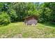 Exterior view of a wooden shed in a green backyard with lush trees at 13821 David St, Huntersville, NC 28078