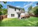 Spacious backyard with a deck, patio, green grass, grill, and furniture, perfect for outdoor activities at 16121 Wrights Ferry Rd, Charlotte, NC 28278