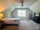 Upstairs bedroom with slanted ceilings, a bed, and a TV at 16121 Wrights Ferry Rd, Charlotte, NC 28278