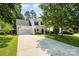 Charming two-story home with a long driveway and well-manicured lawn surrounded by mature trees at 16121 Wrights Ferry Rd, Charlotte, NC 28278