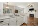 Kitchen featuring stainless steel sink, white countertops and adjacent living room with fireplace at 16121 Wrights Ferry Rd, Charlotte, NC 28278