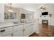 Kitchen featuring stainless steel sink, white countertops and adjacent living room with fireplace at 16121 Wrights Ferry Rd, Charlotte, NC 28278